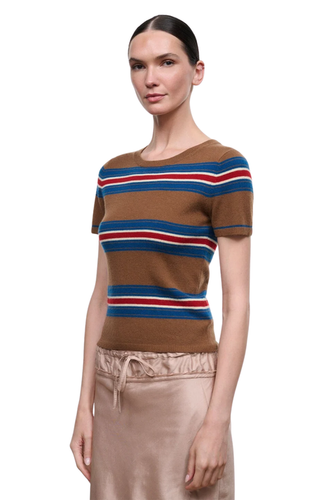 A model wearing a brown short-sleeve knit top with horizontal blue, red, and white stripes, paired with a beige satin skirt, against a plain white background.