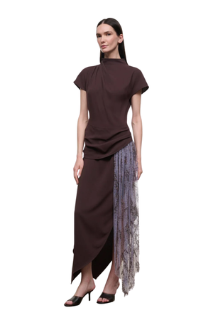 A model wearing a dark brown high-neck dress with short sleeves and a sheer, patterned tulle side panel, set against a plain white background.
