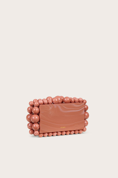 Side view of a marbled peach acrylic clutch in a rectangular design tat featur5es matching acrylic beads in graduating size along the border of the clutch. 