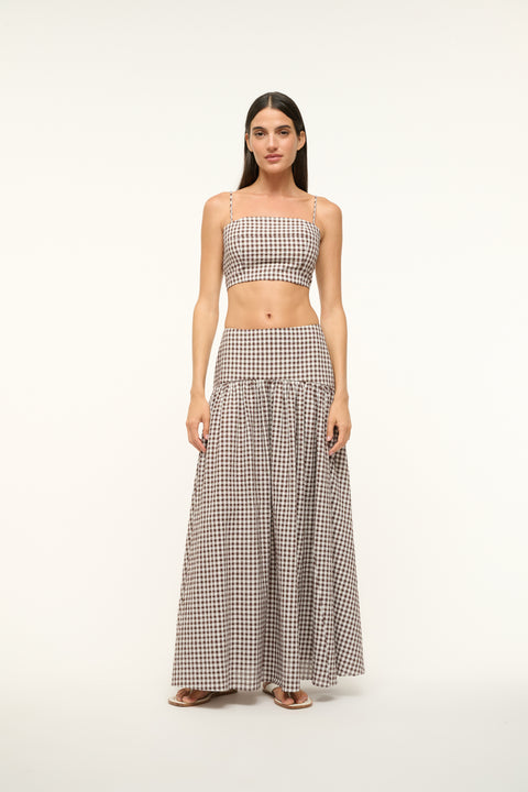 Woman wearing a brown gingham crop top with a matching maxi skirt
