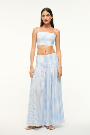 Woman wearing a blue gingham crop top with a matching maxi skirt