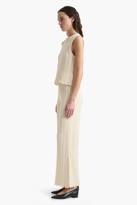 Woman facing the left in matching cotton knitted top and pant set.