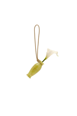 Small decorative calla lily bag charm on a beige background