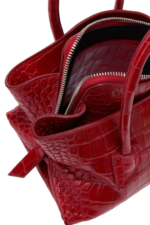 Red crocodile-patterned handbag with a silver zipper on a white background
