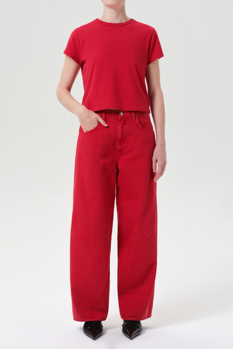 Person wearing a red t-shirt and red wide leg jeans on a white background