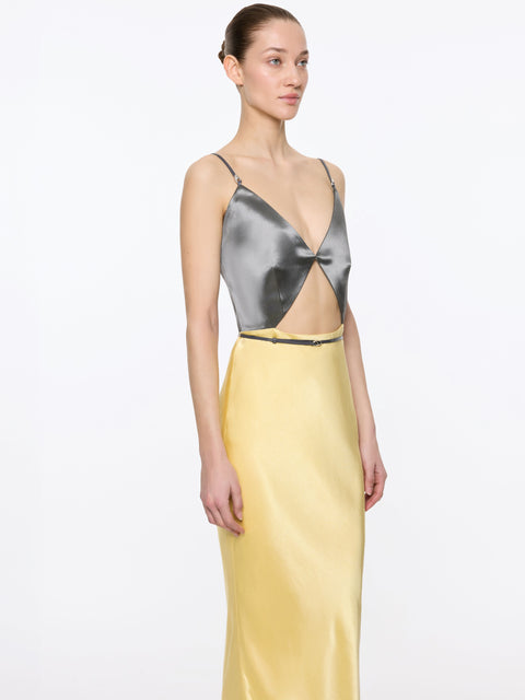 Up close of woman wearing a amxi dress with metallic top and yellow skirt on a white background