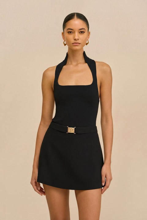 Detail shot of woman wearing a black halter top with square neckline on a white  background