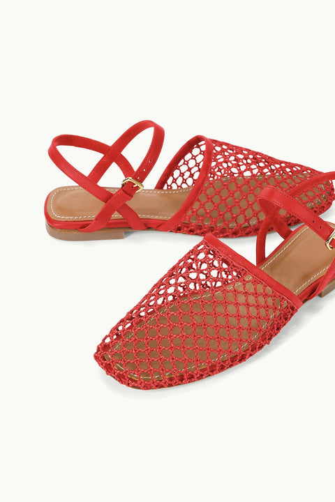 Detail shot of a pair of  red, closed-toe, mesh flat sandals that features criss-cross ankle straps.