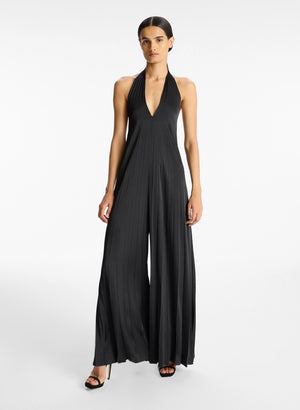 Full body view of a model wearing the pleated black satin jumpsuit