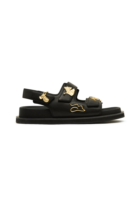 Black sandal with gold charms.