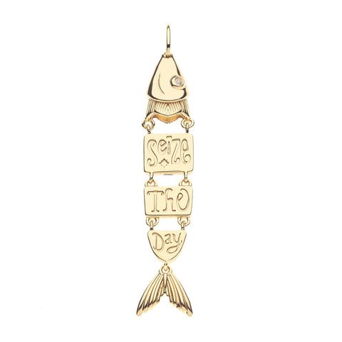 Back of gold fish pendant with engraved text that says 'seize the day' on a white background