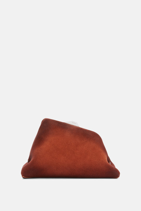 An asymmetrical, trapezoidal clutch made from brushed brown suede with silver hardware and a hidden shoulder strap. 