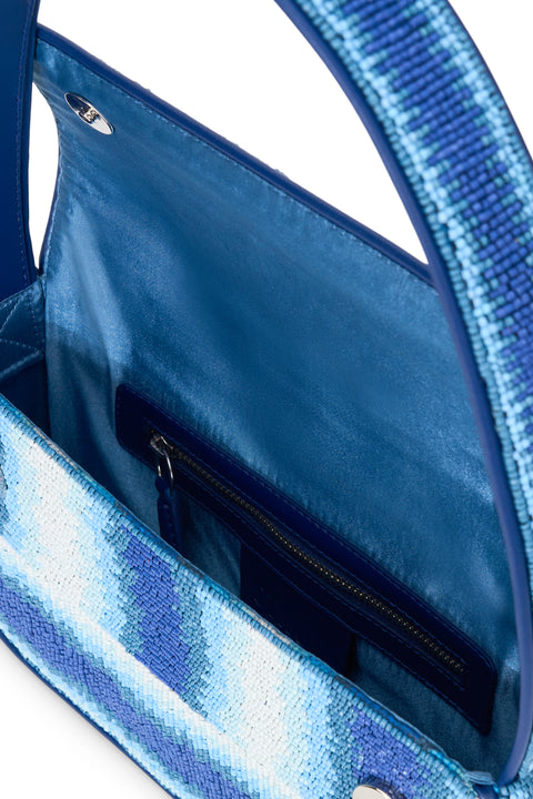 Detail shot of a glass beaded shoulder bag that features blue and white stripes in a subtle wave pattern with dark blue lining.  