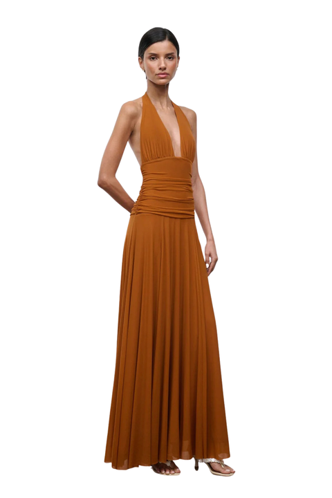 Woman wearing a brown halter neck gown on a white background