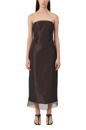Woman wears brown strapless taffeta dress with black shoes.
