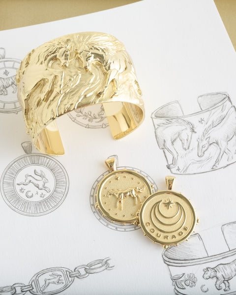 Gold pendants  with engraved horse and courage designs.