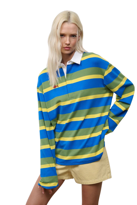 Woman wearing a blue, green, and yellow striped shirt with a white collar and red fish detail on a white background close up
