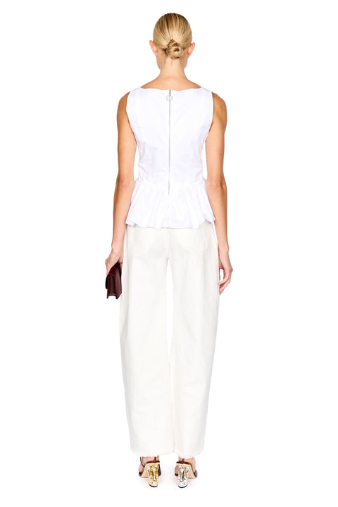 A woman shown from the back wearing a white sleeveless peplum-style top with a visible center zipper and white wide-leg pants, standing against a plain white background.