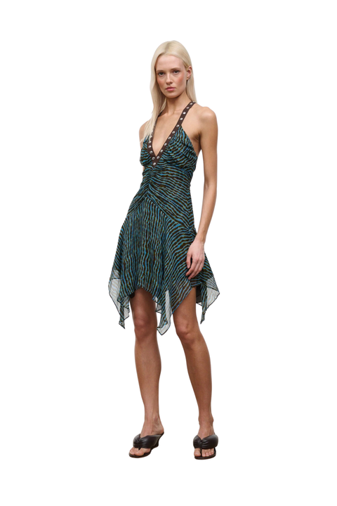 Woman wearing a patterned blue and brown dress with studs on a white background
