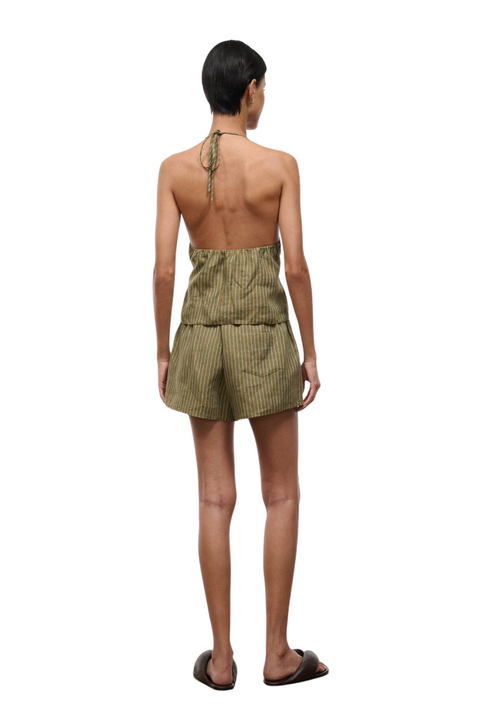 Woman wearing a green striped two-piece shorts set on a white background back angle