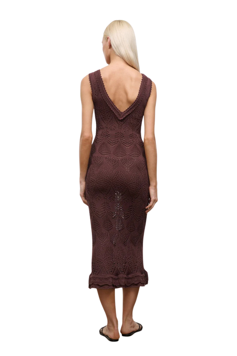 Woman wearing a brown knitted lace dress on a white background back angle