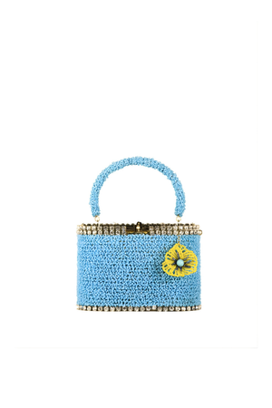 Blue beaded handbag with a yellow flower bag charm detail on a white background
