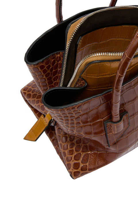 Brown and tan handbag with a silver zipper on a white background