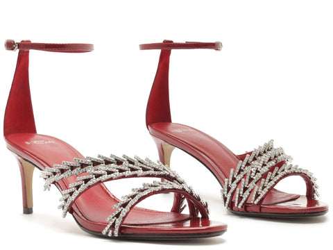 Pair of red high-heeled sandals with silver embellishments on a white background