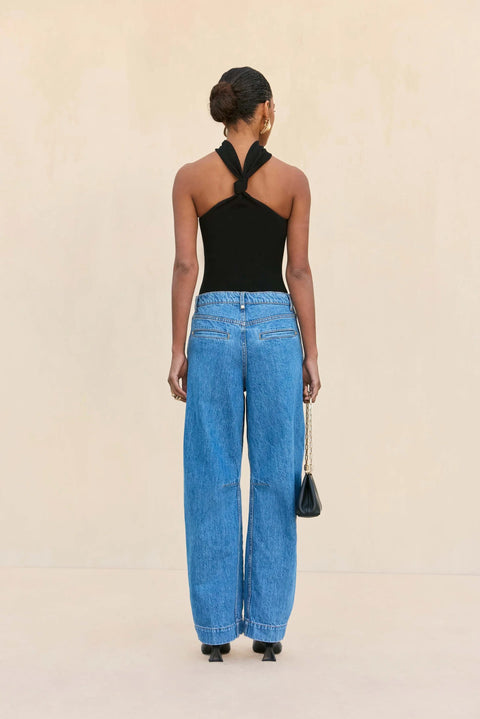 Back view of a woman wearing a strapless black top with an attached choker. 