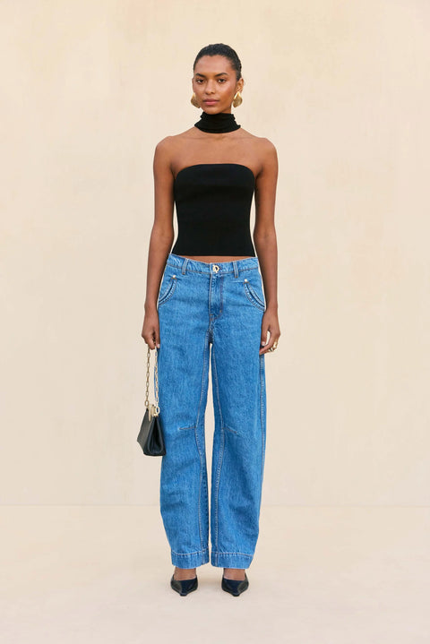 Woman wearing a strapless black top with an attached choker. 